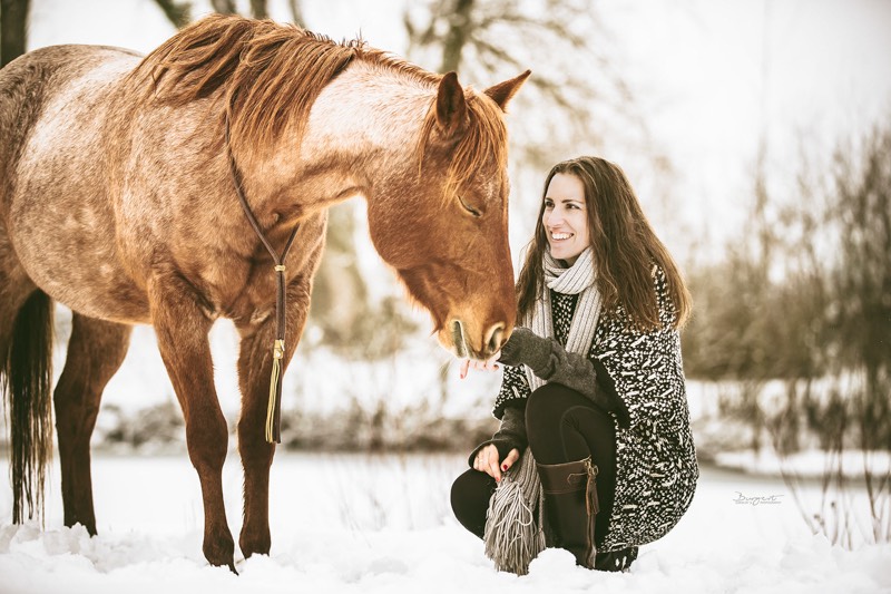 Petra streichelt Carey im Knien im Schnee